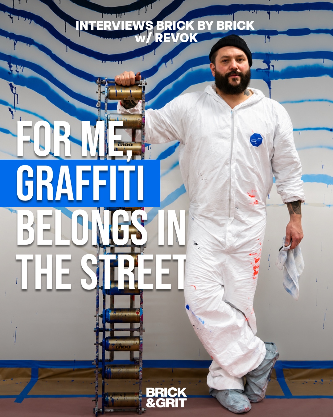 REVOK standing in front of a blue and grey abstract artwork